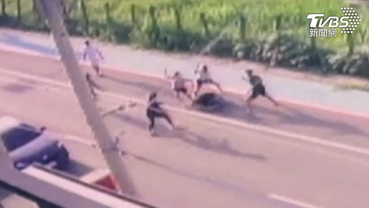 高雄仁武20日清晨六點多，只見一名黑衣男子遭多人團團包圍，隨後一群人持棍棒刀械對他猛力攻擊，血濺馬路倒地不起。（圖／TVBS）