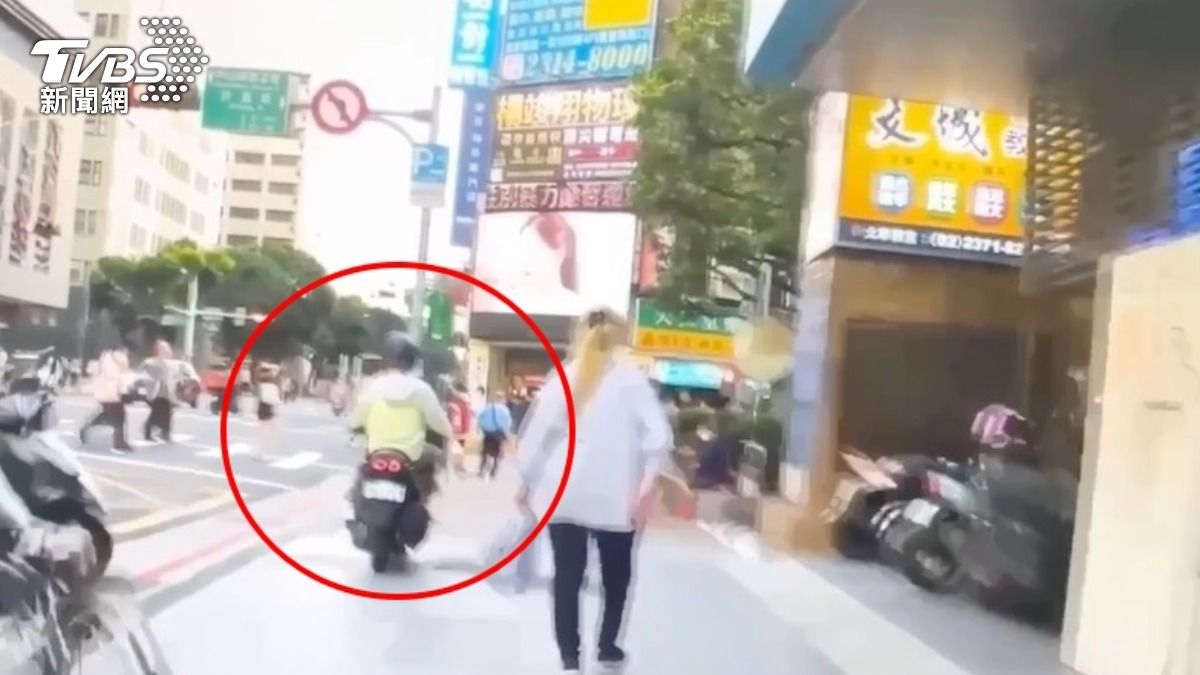 疑似不想等紅燈，男子騎在人行道上，被警方鳴笛示意停下。（圖／TVBS）