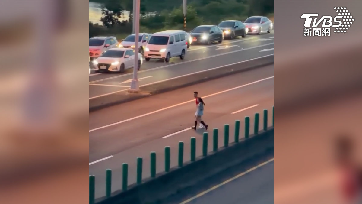 汽機車全塞爆東石週邊的聯外道路,連台61快速道路上都塞成停車場,還有情侶跨越快速道路(圖/翻攝Threads@xiang_2oo4)
