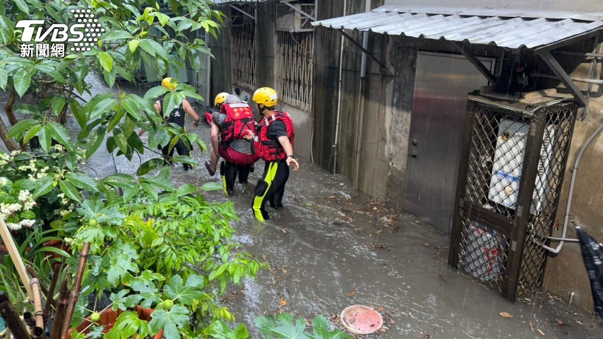 新北市淡水區多處積水,警消救出受困家中的老婦人。(圖/TVBS)