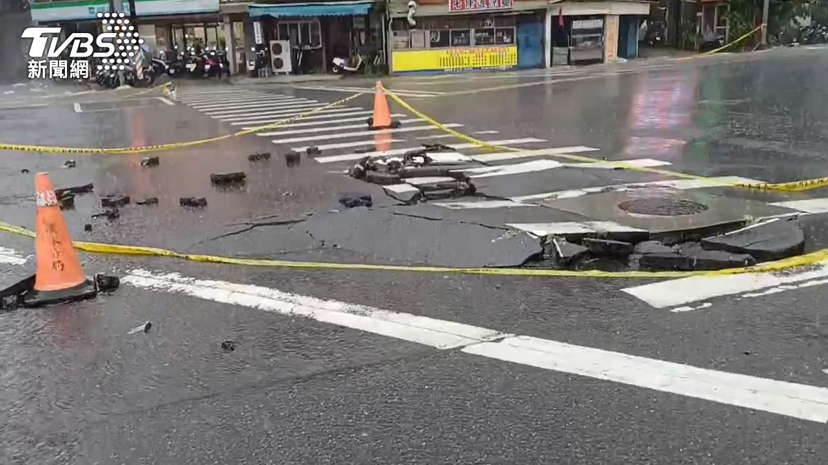 大雨導致地下水管線破裂沖垮路面,警方緊急拉起封鎖線。(圖/TVBS)