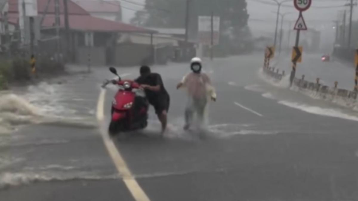 高雄內門25日凌晨起降下豪大雨,一名騎士因水流過強一度困在水中,目擊駕駛立即下車協助。(圖/翻攝Threads_kama88112)