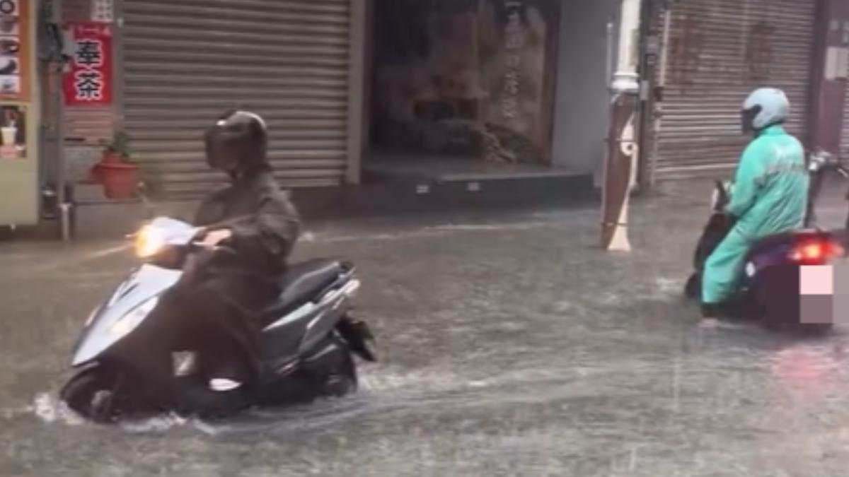 淡水老街淹水,高度超過腳踝,機車騎士只能緩慢通行。(圖/翻攝 Threads@book1.64 )