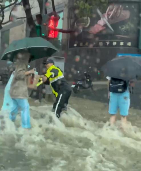 新竹市光復中學附近積水嚴重,學生涉水穿越馬路。(圖/TVBS)