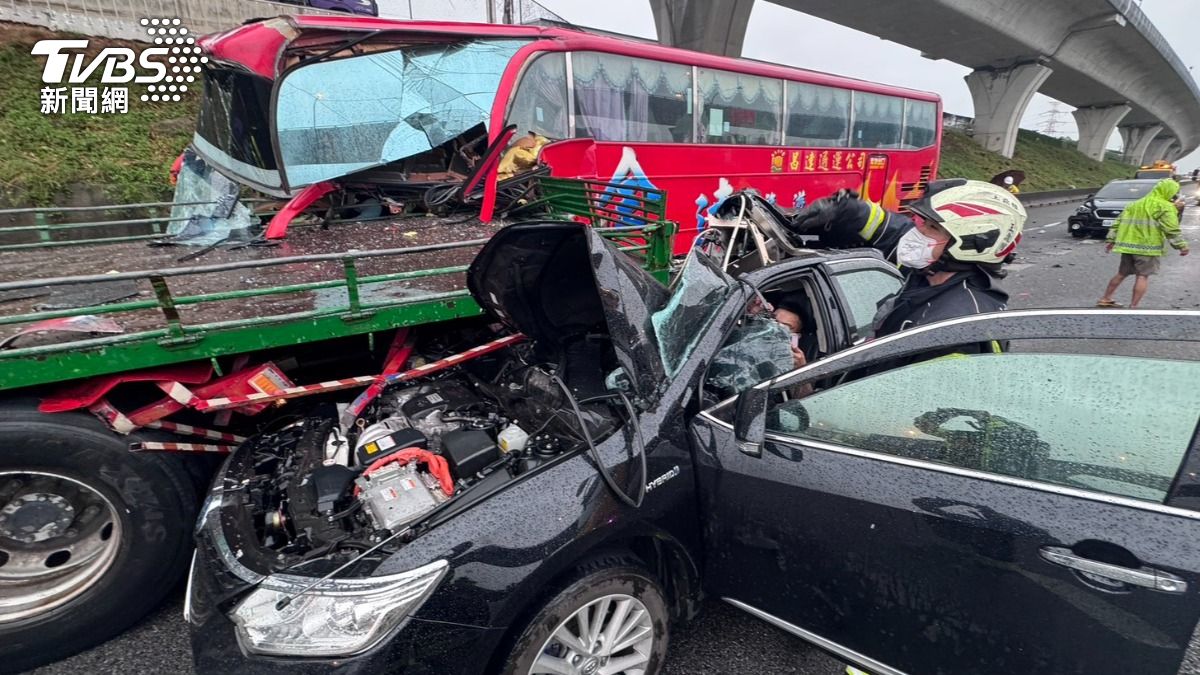 國道一號林口路段發生9車連環撞事故,其中這輛黑車半個車身被卡在貨車後輪。(圖/TVBS)