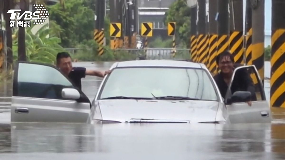 岡山有車主因未注意路況誤入深水區熄火,多名熱心民眾在雨中幫忙推車。(圖/TVBS)