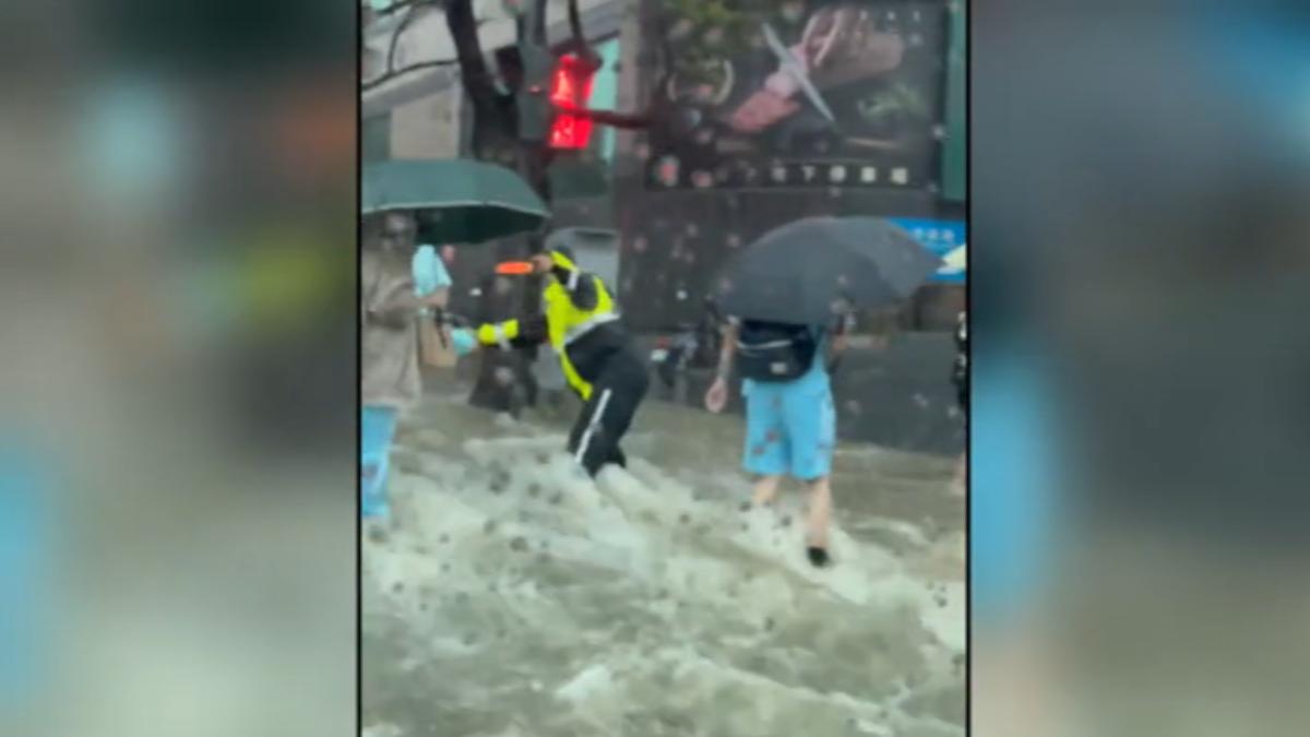 校門口水流湍急,交警協助學生過馬路。(圖/翻攝自Threads)