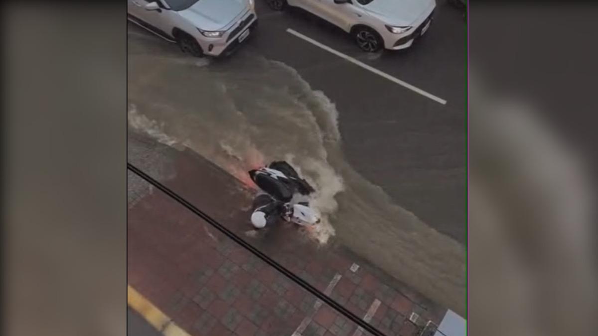 機車騎士騎在光復路上，遭水流沖倒慘摔。（圖／民眾授權使用）