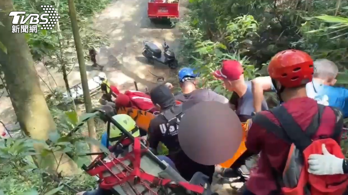 整個坡度十分陡，搜救人員一遍溝通，一邊將患者抬高，緩緩走下山，下山最後一哩路相當艱辛，拉著一旁繩子、踩穩腳步（圖／TVBS）