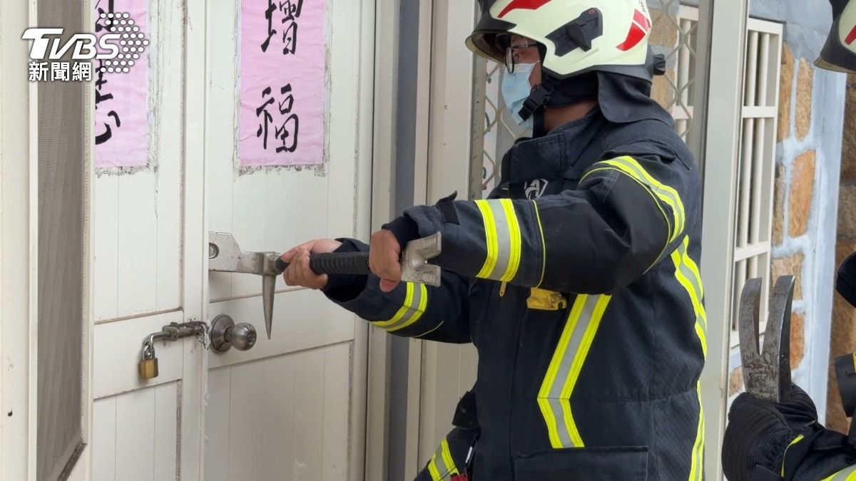 警消利用撬棒破門進入屋內查看。(圖/程子奕攝)