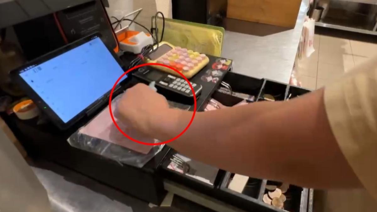 女店員從客人手中接過鈔票,揉在手心內隨後塞進口袋。(示意畫面;圖/TVBS))