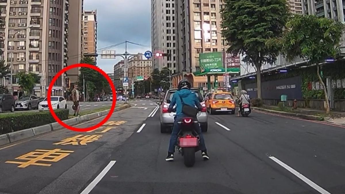 男騎士將馬路當伸展台，還脫帽站在分隔島上。（圖／目擊者提供）