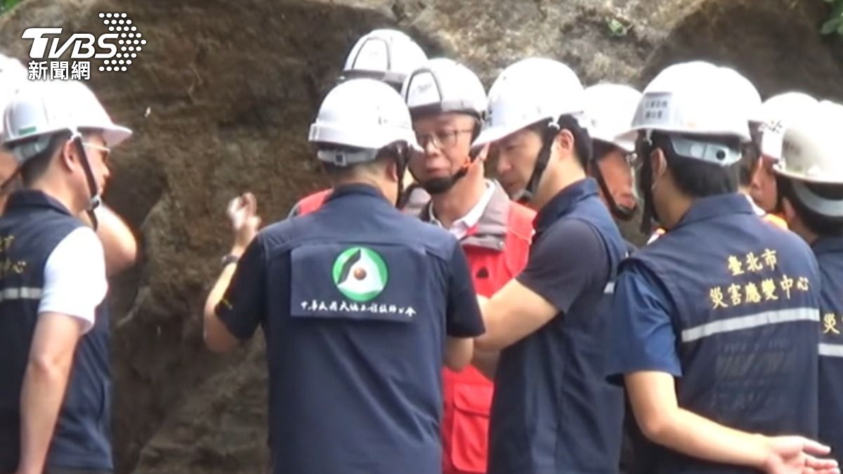 台北市長蔣萬安頭戴安全帽視察北投泉源路,聽取技師說明巨石滑落災情。(圖/TVBS)