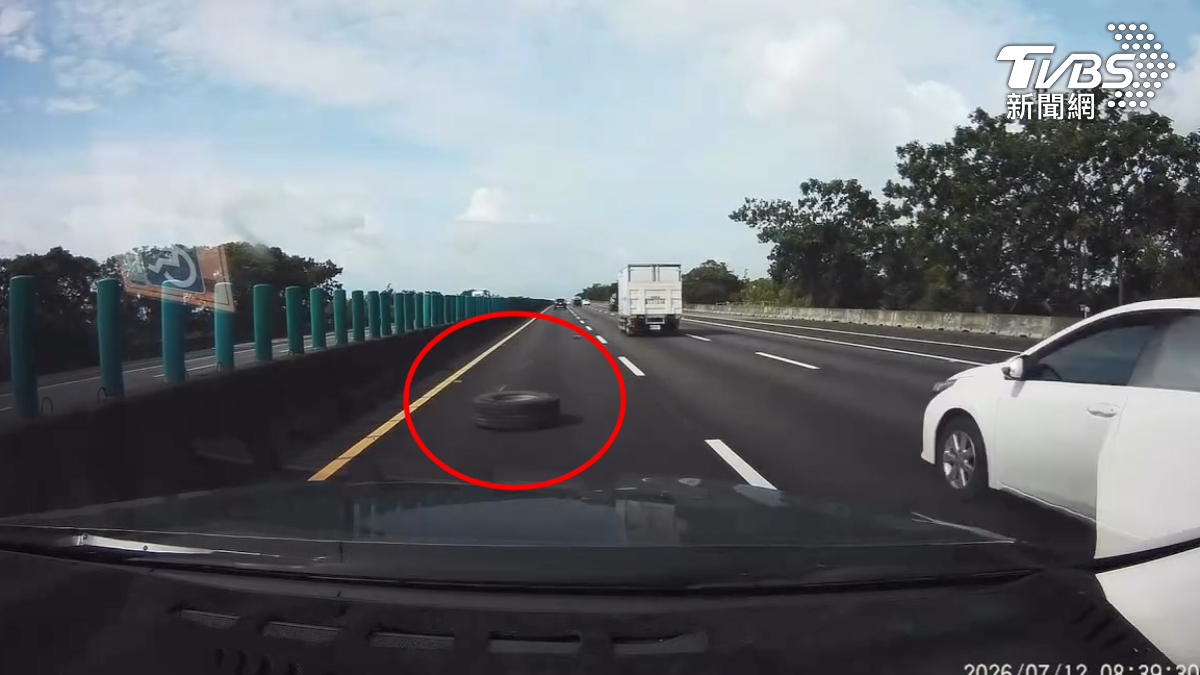 行車紀錄器顯示前方出現掉落的大輪胎,駕駛緊急煞停並準備切換車道。(圖/TVBS)
