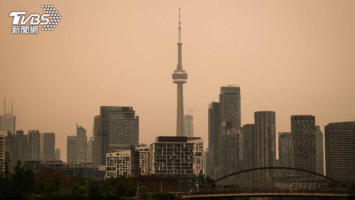 加拿大多倫多地標國家電視塔籠罩在野火煙霧中，城市上空霧霾瀰漫。（圖／達志影像美聯社）
