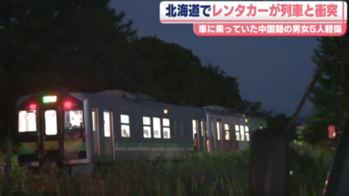 一輛白色小型廂型車在平交道內與火車發生碰撞。（圖／翻攝自日本電視台）