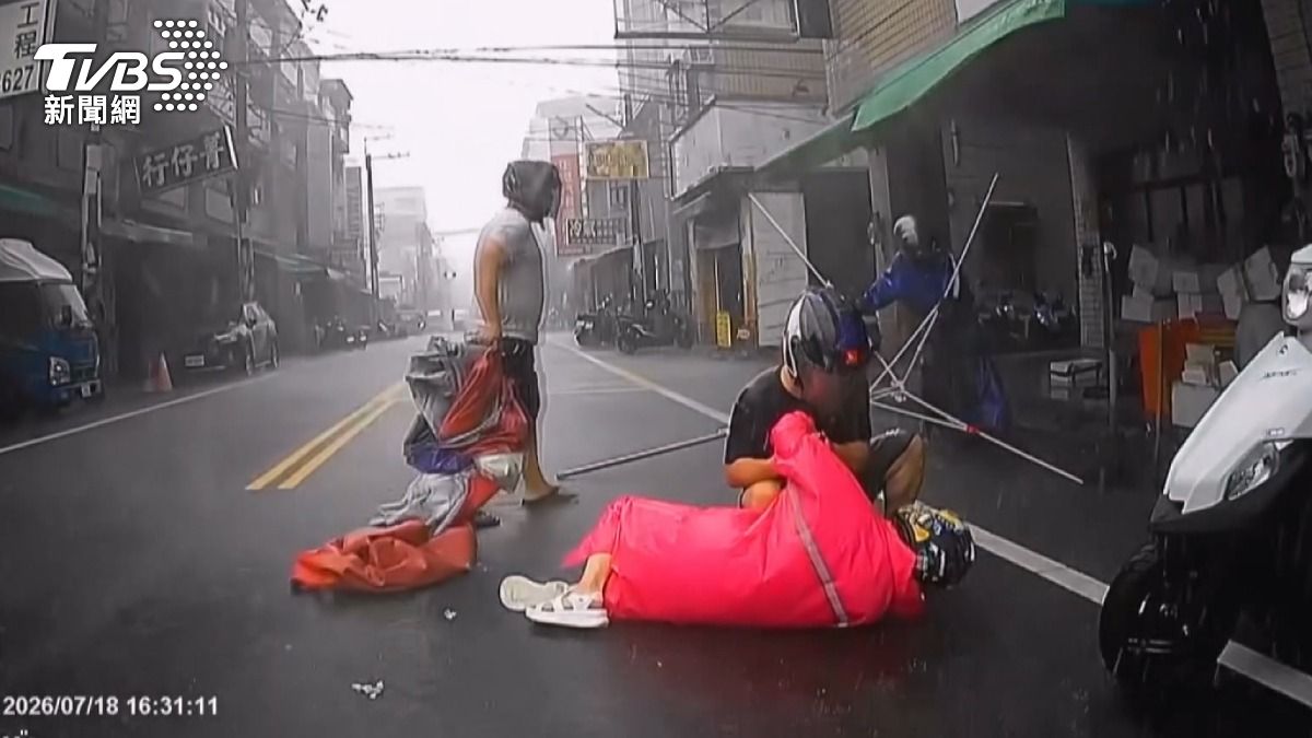 攤販大傘被吹飛砸路中！女騎士閃避不及倒地　熱心民眾協助攙扶(圖／大里人聊天室2.0）