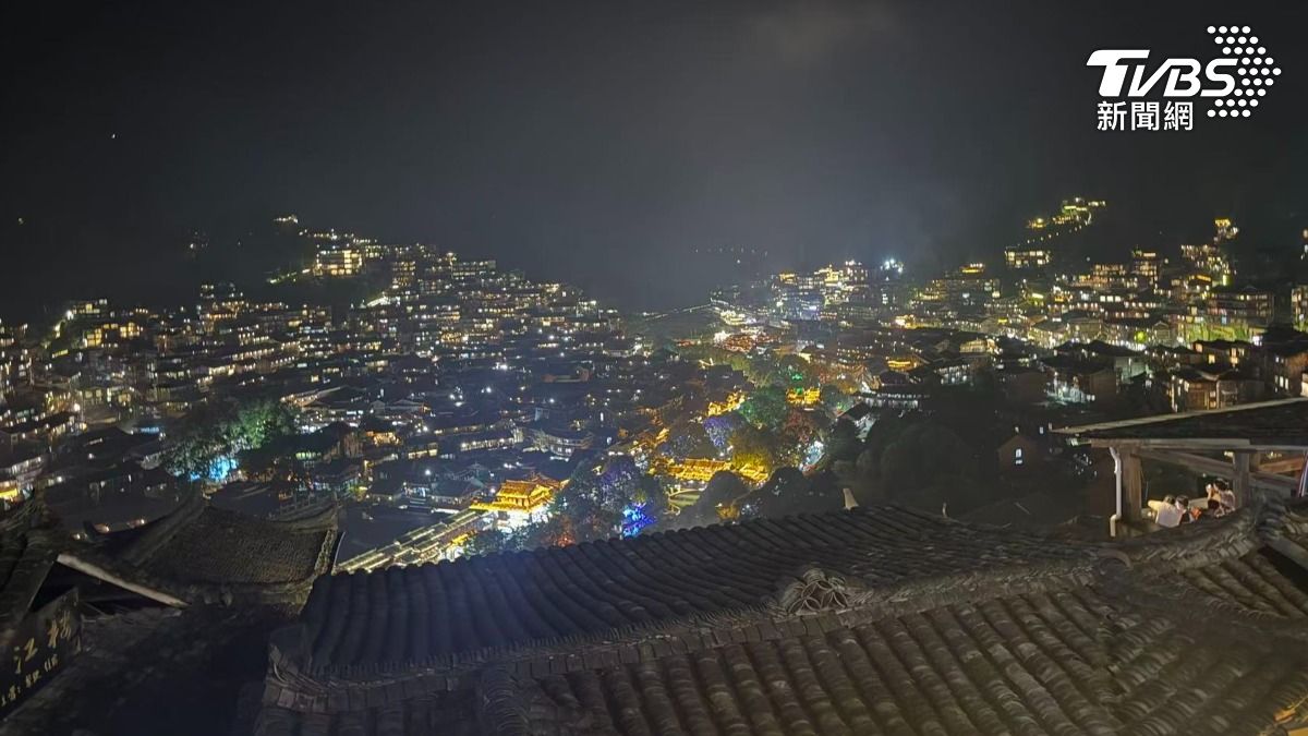 夜幕降臨後,貴州西江千戶苗寨燈火通明,層層吊腳樓點亮山谷,成為暑假熱門打卡景點。(圖/TVBS)
