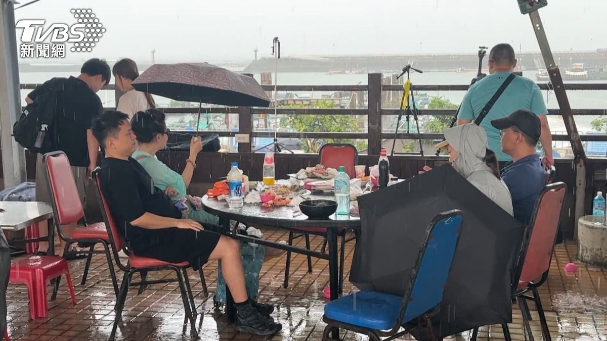 午後一波大雨 吃烤蚵吃到一半的民眾全淋成落湯雞，有人不放棄撐傘也有繼續，但也有人真的擋不住這波雨勢（圖／TVBS）
