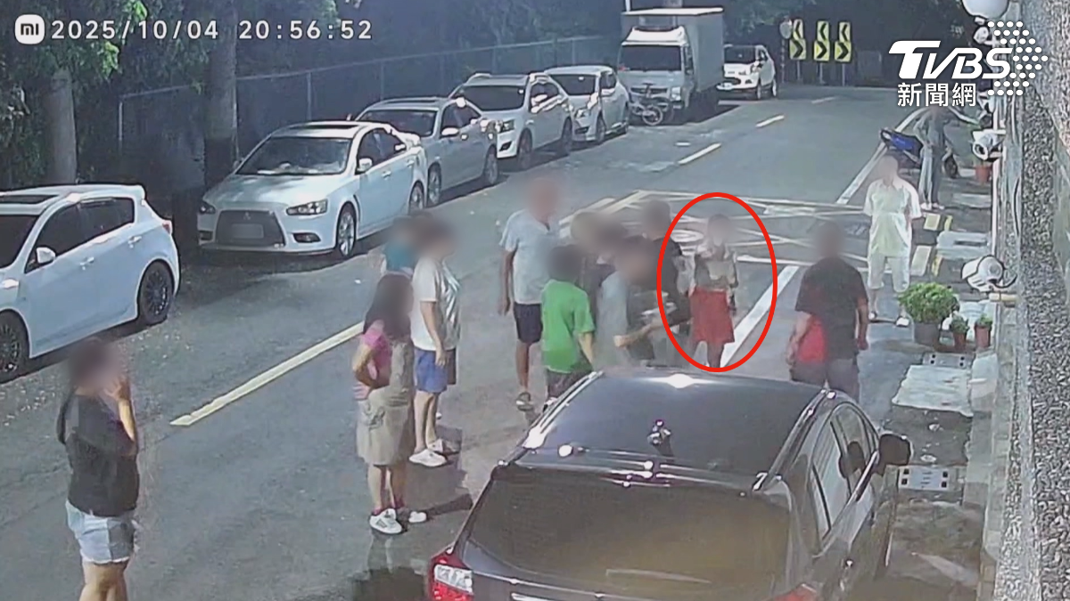 王小姐門口走動，沒多久一輛轎車開過來，按了聲喇叭，王小姐上前理論，結果鄰居全圍上去，衝突一觸即發。（圖／TVBS）