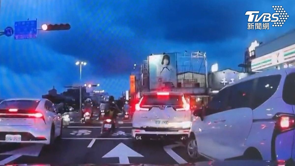 嘉義市區博愛路段晚間突然出現超大陣仗警力，一輛白色轎車遭包夾，駕駛被拖下車壓制。（圖／TVBS）