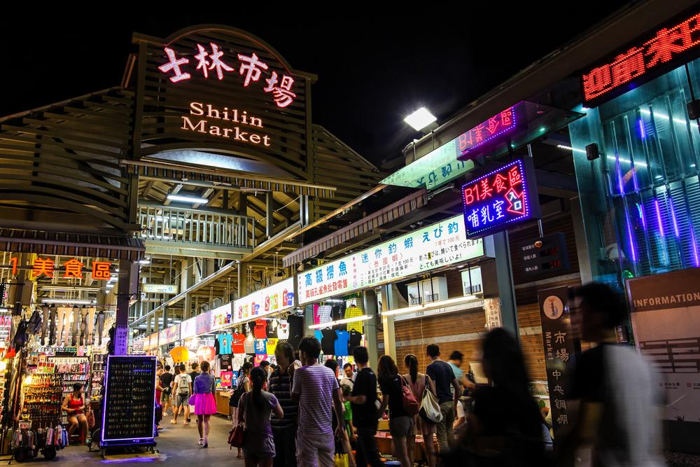 士林夜市從文林路潮流服飾、遊戲攤位,一路延伸到百年古蹟慈誠宮與士林市場建築,構成了吃喝玩樂一站滿足的巨型商圈。(圖/交通部觀光署)