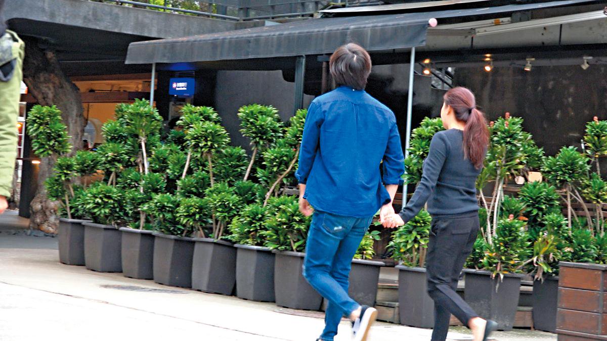 14：17　張傑跟另一半手牽手逛街，兩人不畏台北低溫穿得單薄。