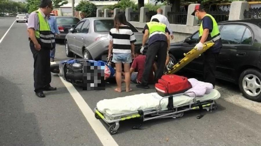 2部機車擦撞後,男騎士滑進轎車車盤底下,等待救援。(警方提供)