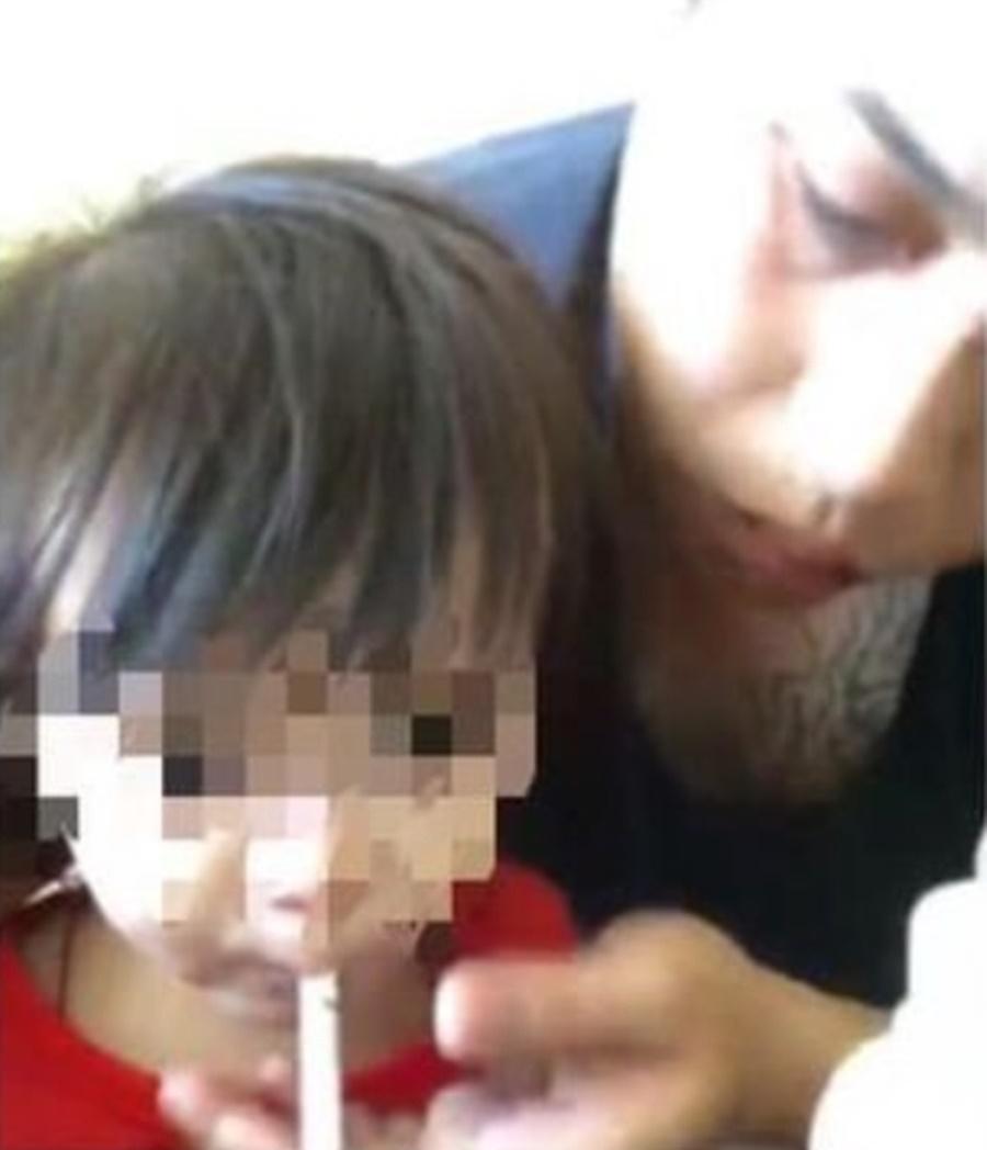 陳姓男子位女童抽菸。(翻攝畫面)